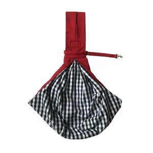 Detailed view of red pet sling carrier with checkered lining and safety leash