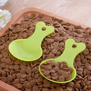 Pair of green candy-colored pet food scoops on a tray of brown kibble pellets.