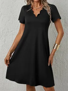 Dettaglio di un abito nero a maniche corte con elegante scollo a V a forma di onda