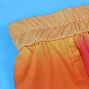 Macrodetail van de elastische tailleband op een rok met een oranje-rood kleurverloop.