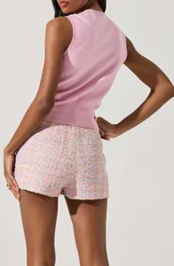 Rear view of woman wearing pink knit sleeveless top and colorful pastel tweed shorts