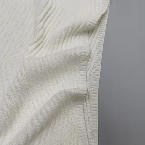 Detailed close-up view of a white knitted vest showing fabric texture and ribbed hem