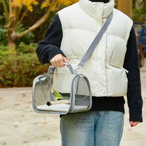 Portable gray bird carrier bag with breathable mesh and clear view window being held.