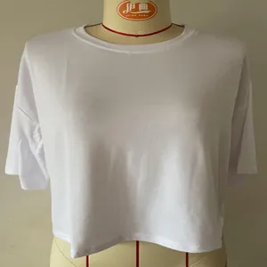 Λεπτομερής προβολή λευκού κοντού T-shirt με στρογγυλή λαιμόκοψη σε κούκλα ραπτικής.