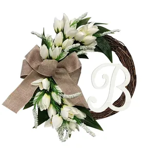 Detailed view of white tulip wreath with burlap bow and white wooden letter B
