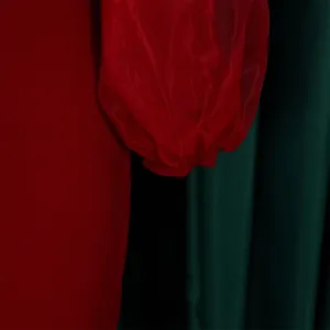 Close-up detail of red sheer mesh lantern sleeve on a women's elegant pencil dress.