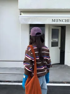 Vue arrière d'un pull polo à rayures pour femme dans une tenue tendance de style urbain.