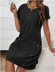 Close-up of black cotton linen dress featuring zipper neckline and decorative buttons
