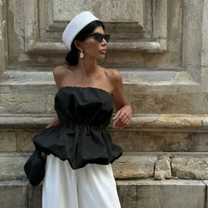 Chic black strapless peplum top styled with white wide-leg trousers for summer outfits