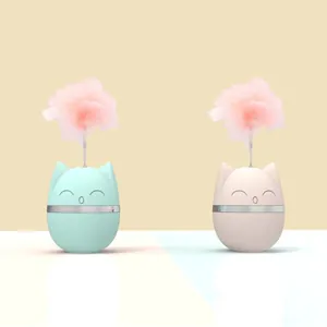 Detailed macro view of cute cat-shaped tumbler toy with soft pink feathers for kittens.