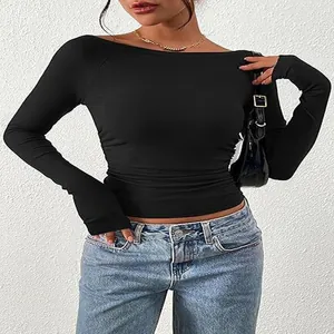 Primo piano di un top corto a maniche lunghe nero da donna con scollo a barchetta e maglia a coste