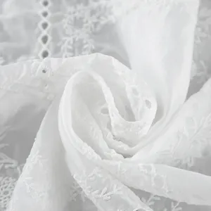 Vue détaillée en gros plan de la broderie anglaise blanche complexe et du beau tissu