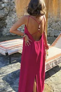 Close-up of fuchsia pink backless maxi dress with cross straps and colorful beads