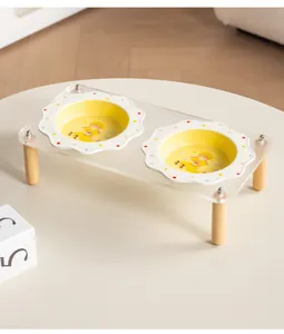 Detail view of scalloped ceramic pet bowls with polka dot design on acrylic stand