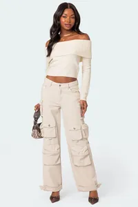 Chic off-the-shoulder cream knitted sweater and multi-pocket beige cargo pants ensemble.