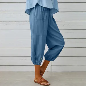 Side view of blue women's cotton linen cropped drawstring pants with button cuffs detail
