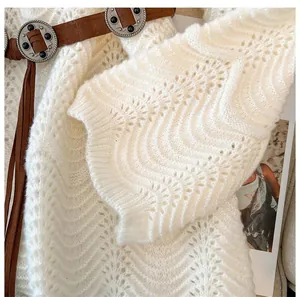 Detailansicht eines weißen Wellen-Hohlstrickpullovers mit Vintage-Gürtel