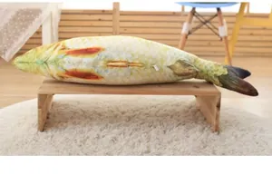 Realistic fish-shaped cat toy placed on a wooden bench in a cozy home setting