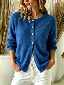 Detailed shot of a cozy blue knit cardigan featuring elegant gold buttons on a model