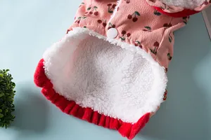 Detail van een hondenwinterjas met warme witte fleecevoering en roze stof met kersenpatroon