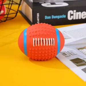 Detailed view of the orange latex squeaky rugby toy for dogs showing textured surface