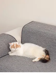 Durable gray textured cat scratcher mat protecting a sofa with a cozy sleeping cat on top