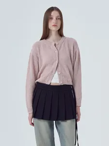 Detailed view of pink knitted long-sleeve cardigan with crew neck and button front.