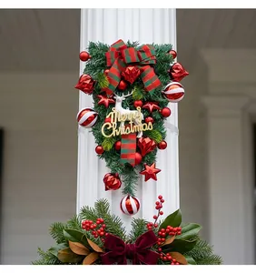 Feestelijke kerst teardrop swag met wit rendier en rode ornamenten op een witte pilaar