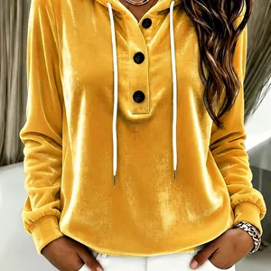 Detail of a yellow velvet hooded sweatshirt featuring white drawstrings and black buttons.