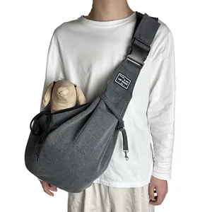 Close-up detail of gray foldable breathable pet carrier bag worn by a person crossbody