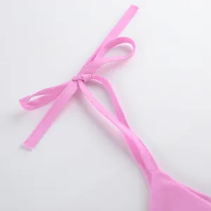 Détail en gros plan montrant la bride à nœud réglable d'un haut caraco en coton rose