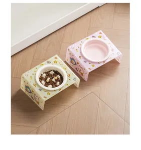 Close-up of ceramic pet bowls with cute cartoon patterns on slanted acrylic stands