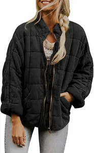 Detail view of a black women's oversized quilted jacket with a stand-up collar and zipper.