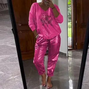 Vibrant pink two-piece set featuring long-sleeve printed top and shiny joggers