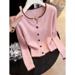 Close-up shot of a soft pink knit cardigan featuring brown contrast trim and buttons