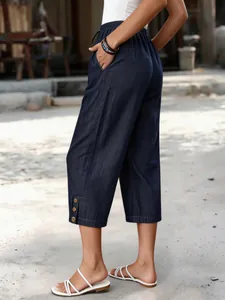 Seitenansicht der bequemen dunkelblauen Tencel-Denim-Caprihose mit dekorativen Knöpfen