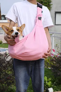 Pink pet sling carrier with a cute Corgi dog, showing the adjustable strap buckle.