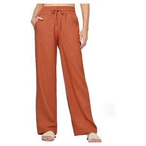 Detailed view of terracotta linen wide-leg pants with high waist and pockets.