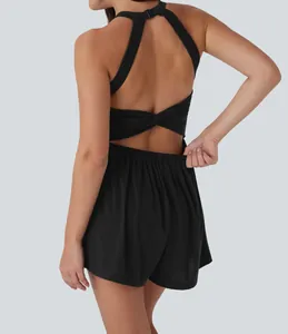 Close-up back view of a black halter-neck romper with twist detail and elastic waist