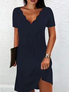 Dettaglio di abito blu navy a maniche corte con scollatura a V smerlata sulla modella