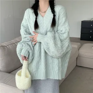 Vista dettagliata di un elegante maglione a trecce con scollo a V verde menta oversize.
