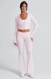 Completo in maglia rosa chiaro con giacca corta con cappuccio e pantaloni a zampa eleganti