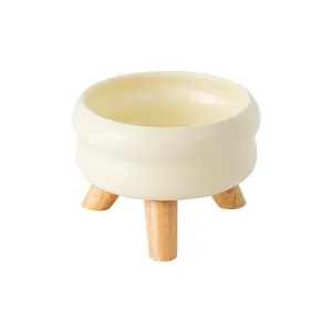 Elegante crèmewitte keramische voerbak met minimalistisch houten statief voor katten en honden