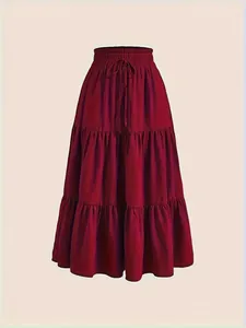 Close-up of a burgundy red tiered maxi skirt with a high elastic drawstring waist.