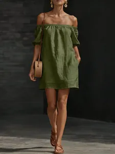 Close-up of olive green cotton linen off-shoulder dress with stylish pocket detail.