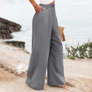 Vista dettagliata di pantaloni grigi a gamba larga a vita alta da donna in spiaggia.