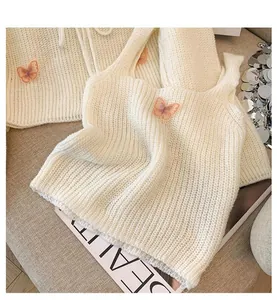 Close-up of French-style knit two-piece set with 3D butterfly patches.