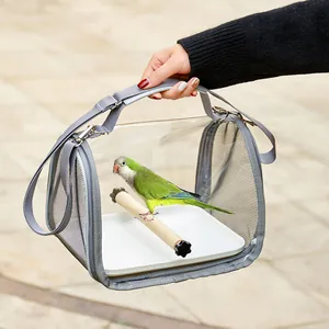 Close-up view of a portable transparent bird carrier bag featuring a green parrot on a perch