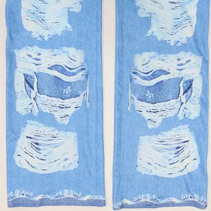 Gros plan d'un pantalon évasé bleu clair avec imprimé délavé et motifs artistiques