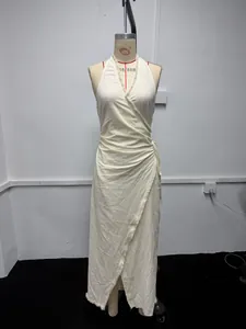 Detailansicht eines cremefarbenen Neckholder-Wickelkleides mit Fransen auf Mannequin.